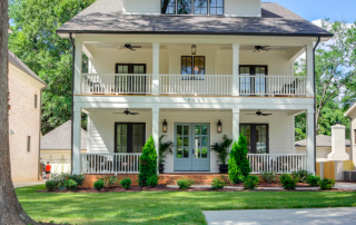 Three story white siding home black trim windows light blue double front door two story front porch black ceiling fans