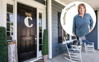 Black front door with white trim windows black shutters front porch with white rocking chairs and photo of Stephanie Therrell in the upper right