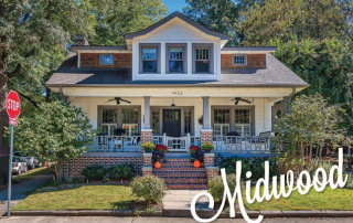 Two story white home with gray shingle detail and gray trim and columns red brick around large front porch black front door